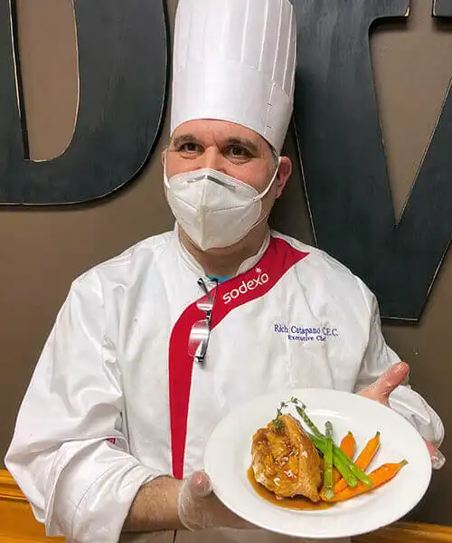 Professional chef showing plate at Dominican Village